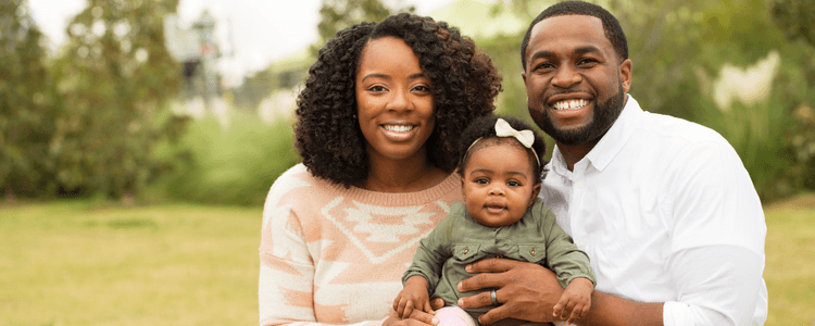 mom and dad and baby smiling at camera