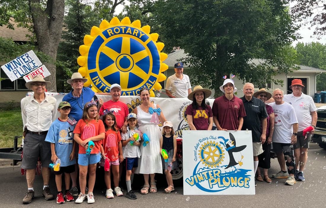 A photo from the Forest Lake 4th of July Parade of part of our club in front of our float. 