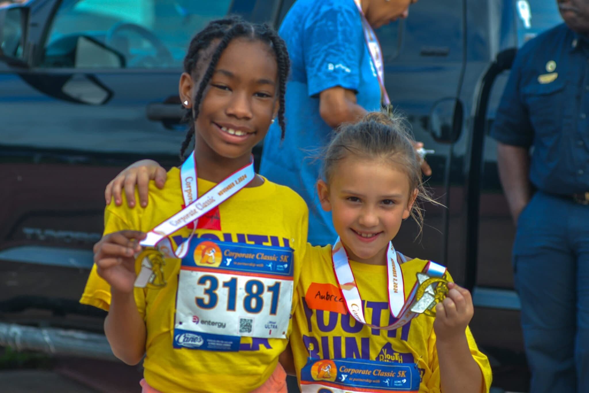 Smiling woman giving a piggyback ride to a laughing young girl.