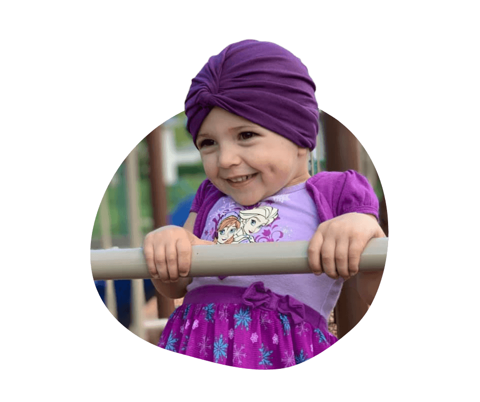 Little girl with cancer playing at the park