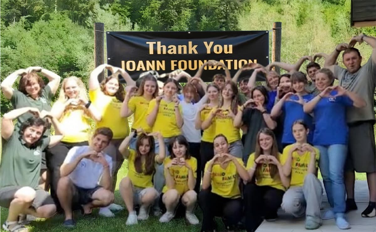 A group of our children in summer retreat thanking donors by making hearts with their hands