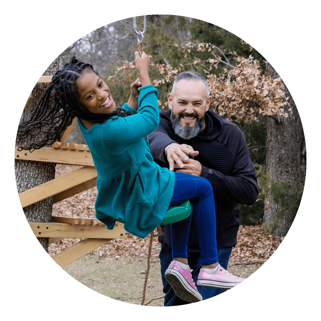 Young child swinging with a father figure male