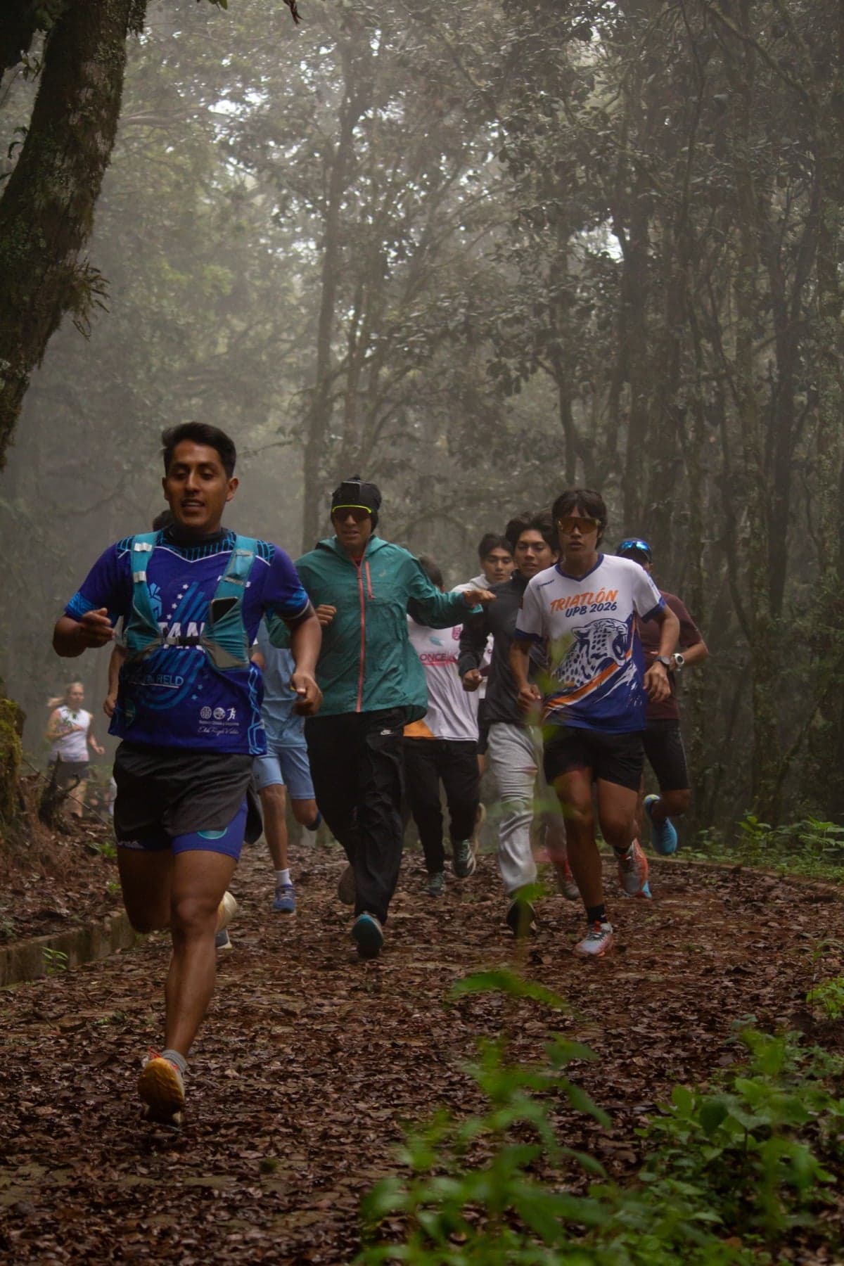 Juan Zurita Victoria leads a group training run on a misty forest trail in Oaxaca.